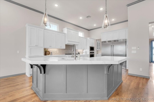 4255 S 173rd E Ave, Tulsa, OK 74134 - kitchen with crown molding, light countertops, white cabinets, backsplash, and a large island with sink