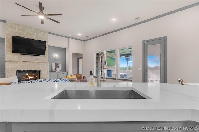 4255 S 173rd E Ave, Tulsa, OK 74134 - kitchen with open floor plan, a stone fireplace, recessed lighting, ornamental molding, and a ceiling fan
