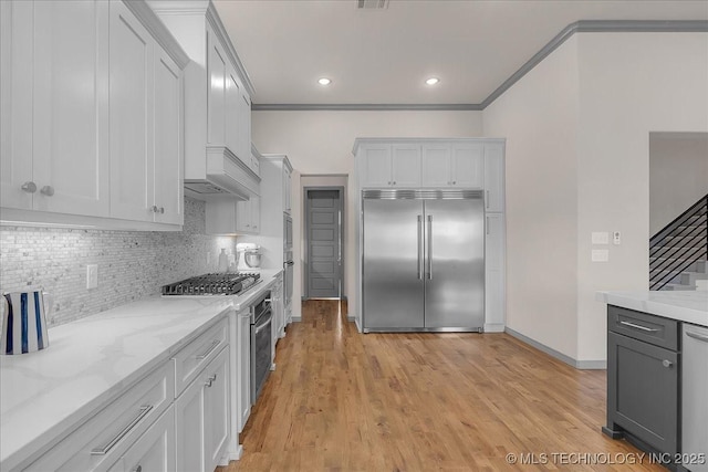 4255 S 173rd E Ave, Tulsa, OK 74134 - kitchen with appliances with stainless steel finishes, crown molding, backsplash, light stone counters, and light wood-style floors