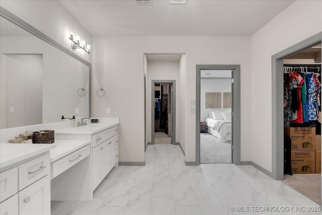 4255 S 173rd E Ave, Tulsa, OK 74134 - bathroom with a walk in closet, vanity, ensuite bathroom, and marble look tile flooring