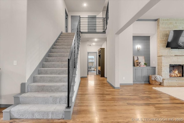 4255 S 173rd E Ave, Tulsa, OK 74134 - stairway with wood finished floors, a stone fireplace, and a high ceiling