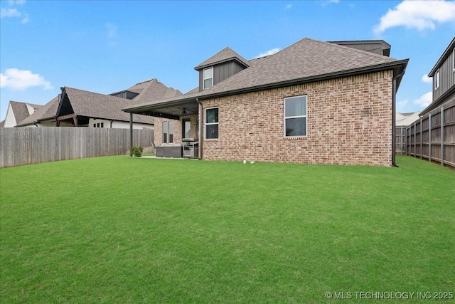 4255 S 173rd E Ave, Tulsa, OK 74134 - rear view of house with a fenced backyard, brick siding, a shingled roof, and ceiling fan