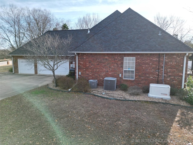 view of home's exterior with cooling unit and a garage