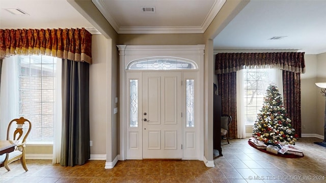 tiled entrance foyer with crown molding and a wealth of natural light