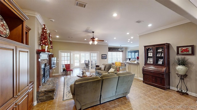 tiled living room with a fireplace, ceiling fan with notable chandelier, and crown molding