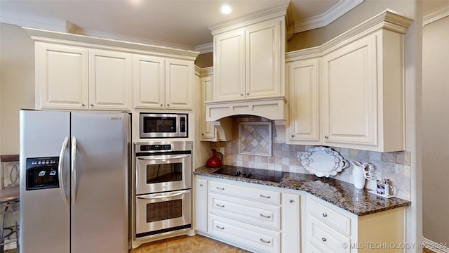 kitchen with white cabinets, decorative backsplash, dark stone countertops, ornamental molding, and stainless steel appliances