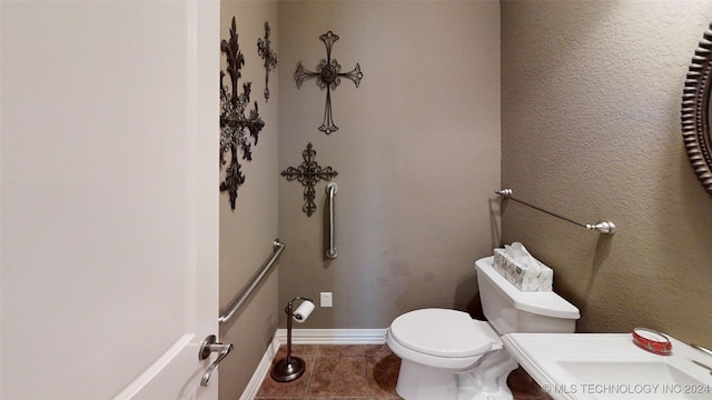 bathroom featuring tile patterned flooring, toilet, and sink