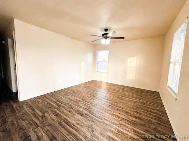 empty room with ceiling fan and dark hardwood / wood-style floors