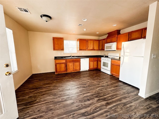 kitchen featuring dark hardwood / wood-style flooring, white appliances, and sink