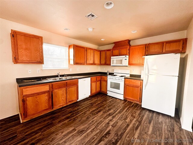 kitchen with dark hardwood / wood-style flooring, white appliances, and sink