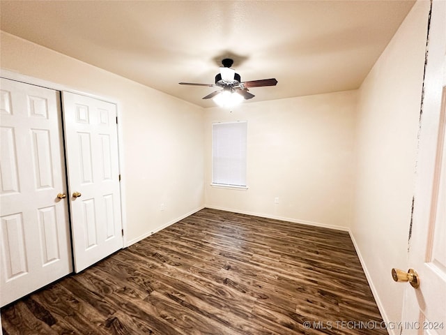 unfurnished bedroom with ceiling fan and dark wood-type flooring