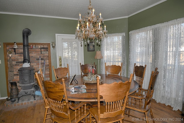 dining space with hardwood / wood-style floors, a wood stove, an inviting chandelier, ornamental molding, and a textured ceiling