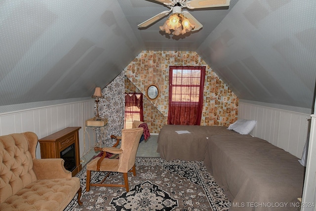 bedroom featuring carpet, wooden walls, ceiling fan, and lofted ceiling