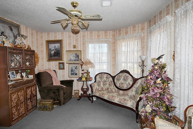 sitting room with carpet flooring, ceiling fan, and a textured ceiling