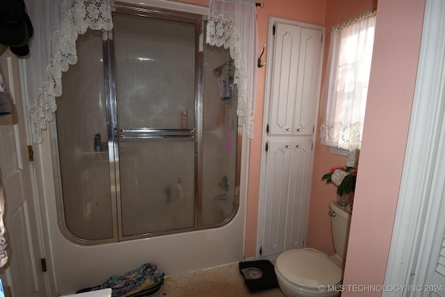 bathroom with tile patterned floors, enclosed tub / shower combo, and toilet