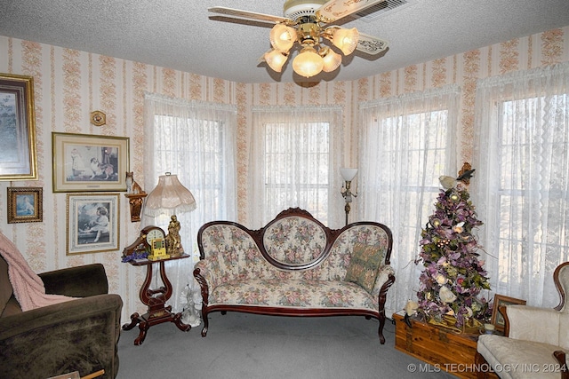 sitting room featuring carpet, a textured ceiling, and ceiling fan