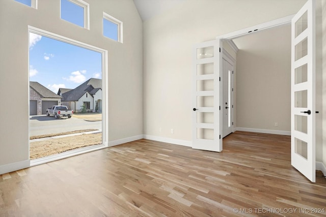 empty room featuring built in shelves and hardwood / wood-style flooring