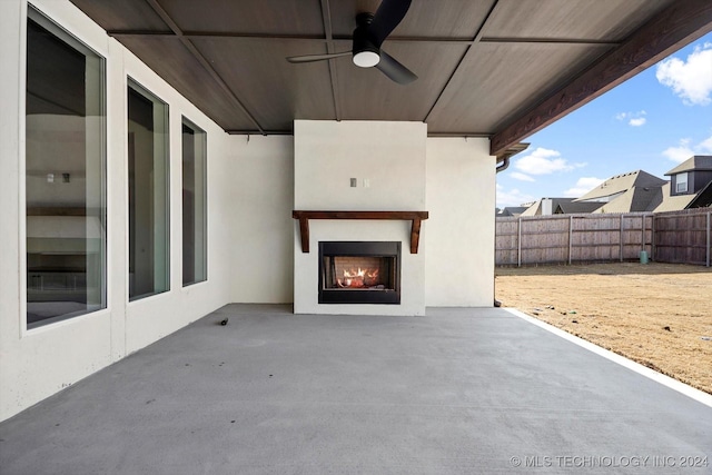 view of patio / terrace with ceiling fan and an outdoor fireplace