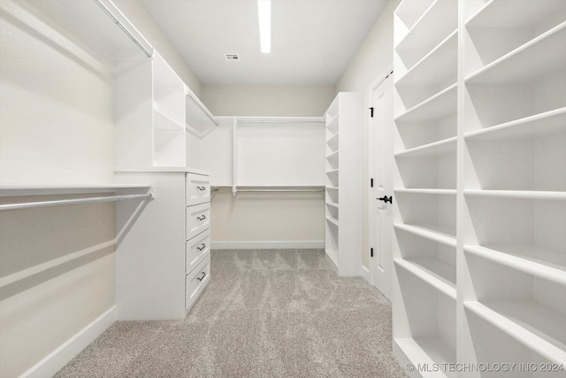 walk in closet featuring light carpet