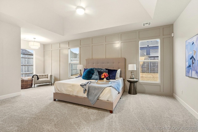 carpeted bedroom with a tray ceiling