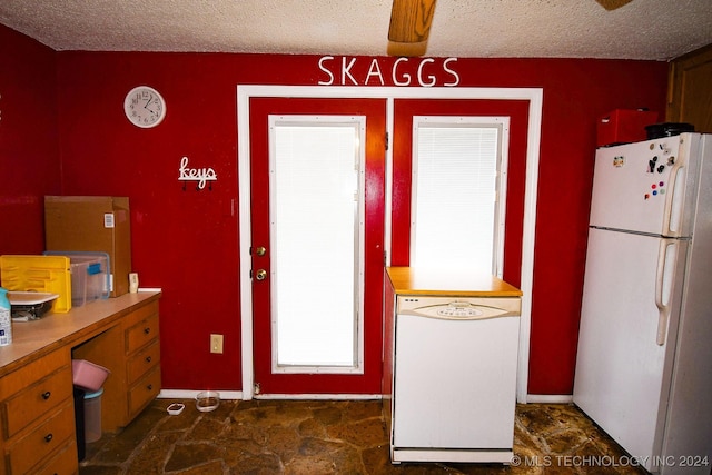 kitchen featuring a textured ceiling, white appliances, and ceiling fan