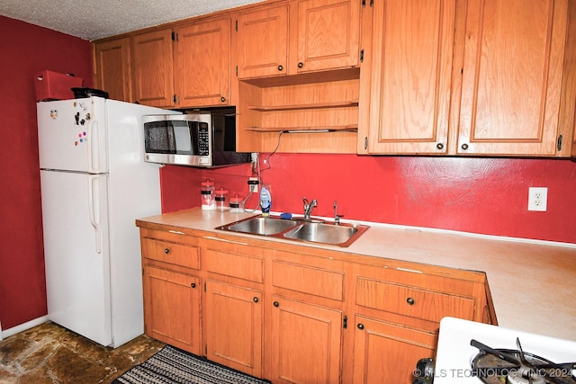 kitchen with range, a textured ceiling, white fridge, and sink