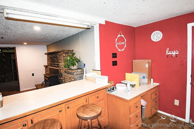 kitchen with a kitchen breakfast bar and a textured ceiling