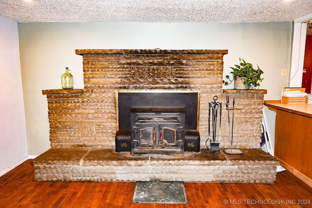 details featuring hardwood / wood-style flooring, a wood stove, and a textured ceiling