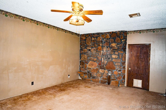 carpeted empty room with ceiling fan and a textured ceiling