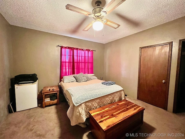 bedroom with ceiling fan, carpet floors, and a textured ceiling