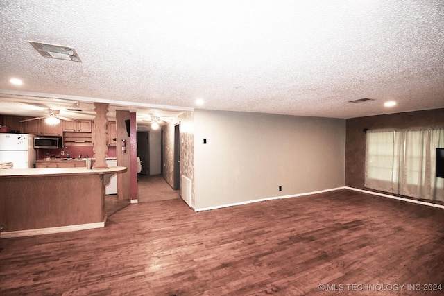 unfurnished living room featuring a textured ceiling, dark hardwood / wood-style flooring, and ceiling fan