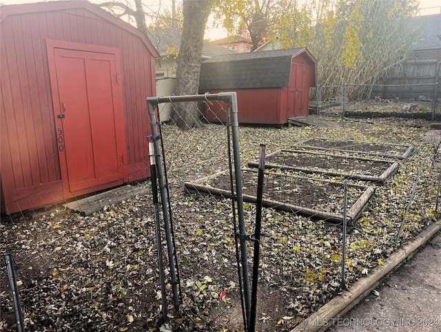 view of shed featuring a garden, a gate, and fence