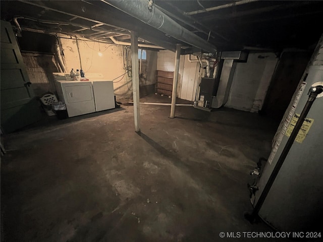 unfinished basement featuring washer and dryer and heating unit