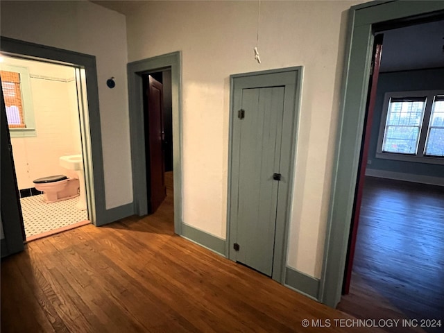 corridor featuring wood finished floors and baseboards