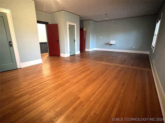 spare room featuring baseboards and wood finished floors