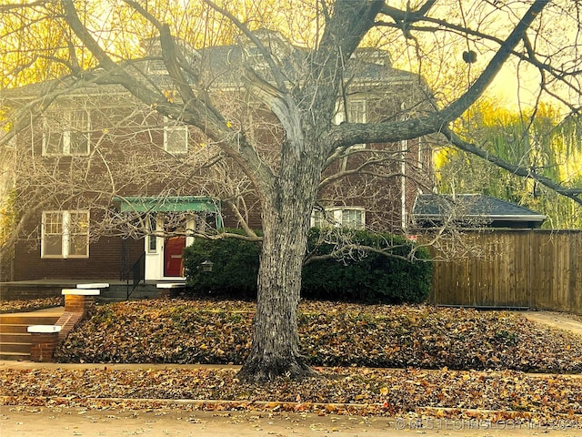 view of front of house with brick siding and fence