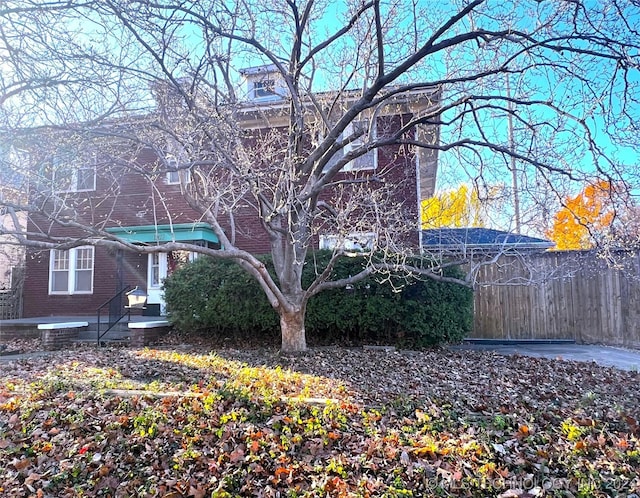 view of front facade with fence and brick siding