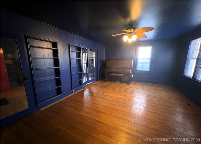 unfurnished living room featuring ceiling fan, french doors, wood finished floors, and visible vents