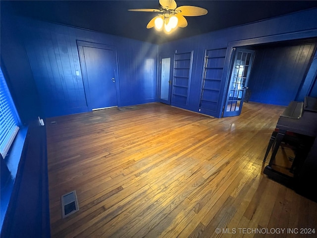 unfurnished bedroom with hardwood / wood-style flooring, visible vents, and a ceiling fan