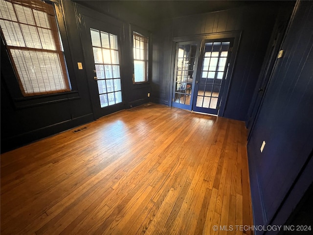 interior space with a healthy amount of sunlight, hardwood / wood-style flooring, and visible vents