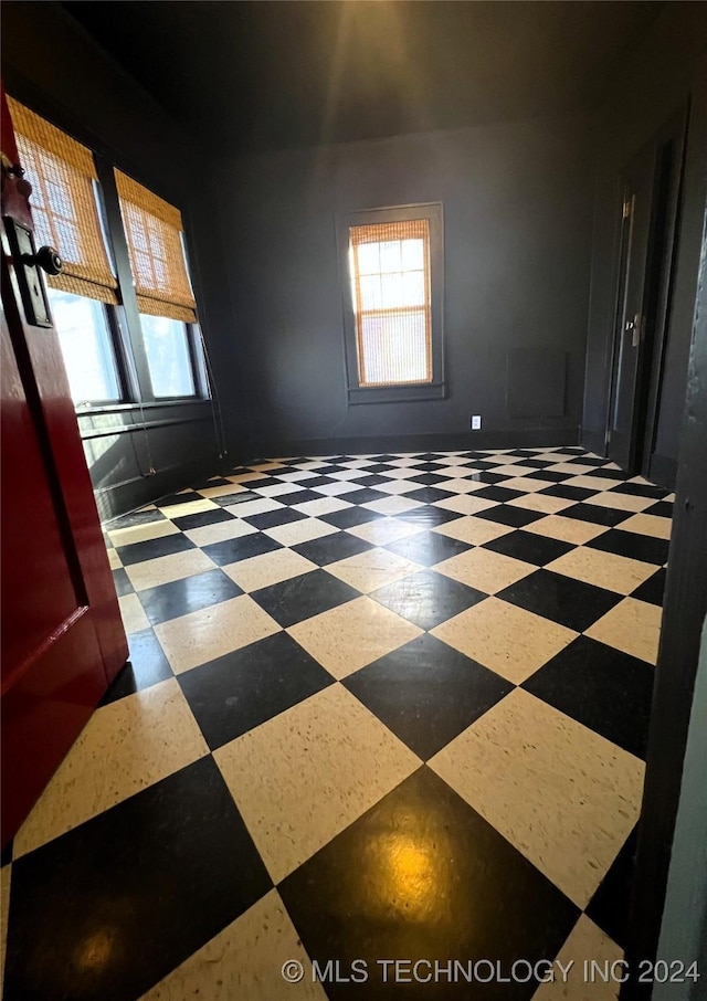 empty room featuring baseboards and tile patterned floors