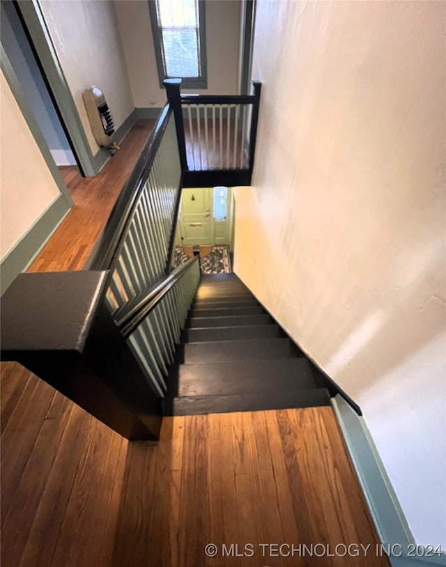 stairway featuring wood-type flooring and baseboards