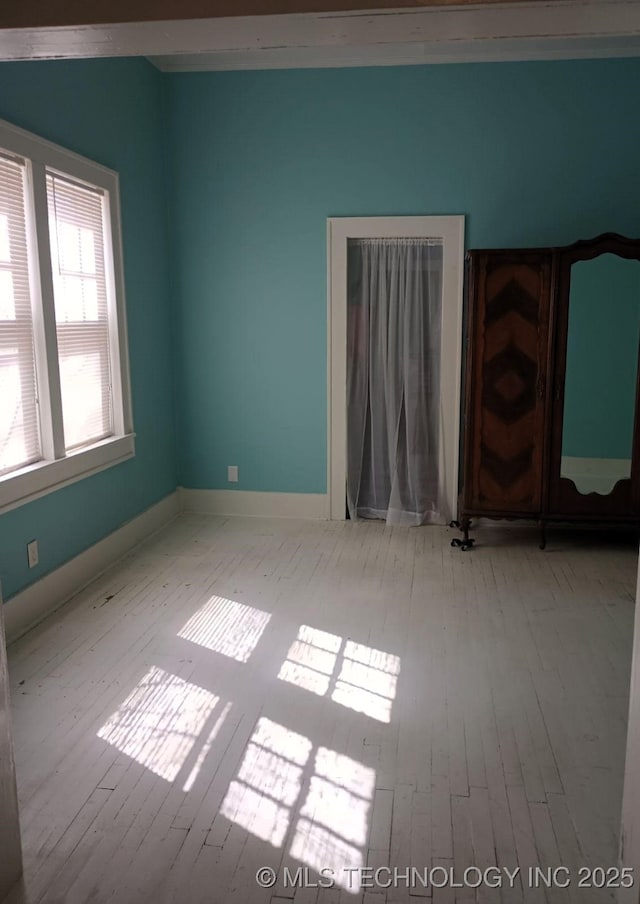 unfurnished room featuring baseboards and wood finished floors