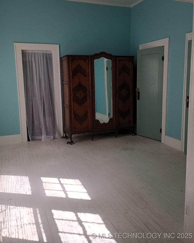 unfurnished bedroom with baseboards and wood finished floors