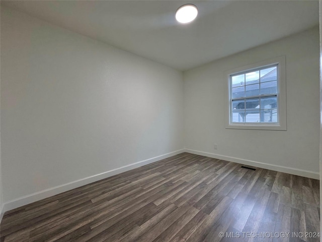 unfurnished room with dark hardwood / wood-style flooring