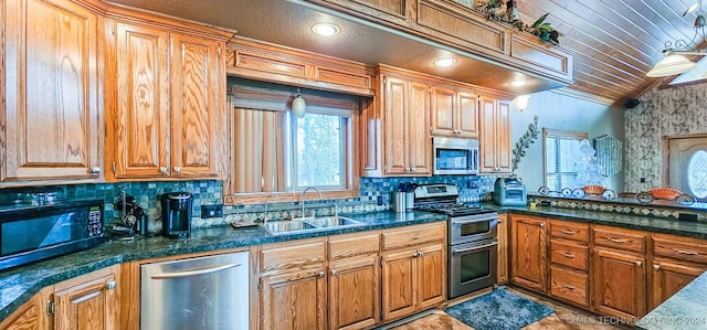 kitchen featuring backsplash, sink, stainless steel appliances, and lofted ceiling