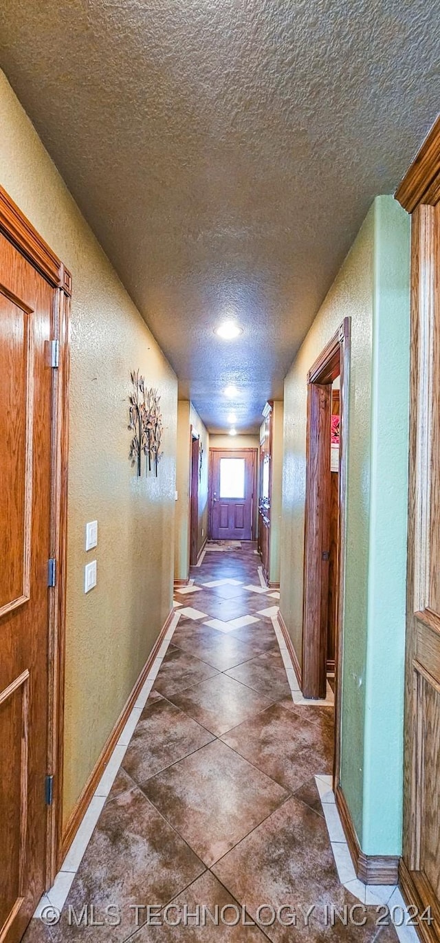 hall with a textured ceiling