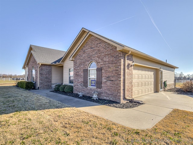 view of side of property featuring a lawn and a garage