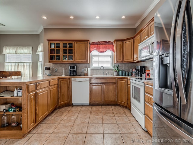 kitchen featuring backsplash, crown molding, sink, and white appliances