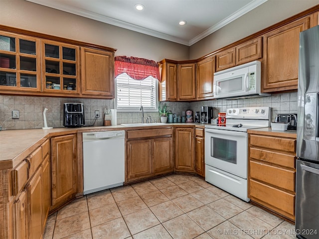 kitchen with white appliances, backsplash, crown molding, sink, and light tile patterned floors